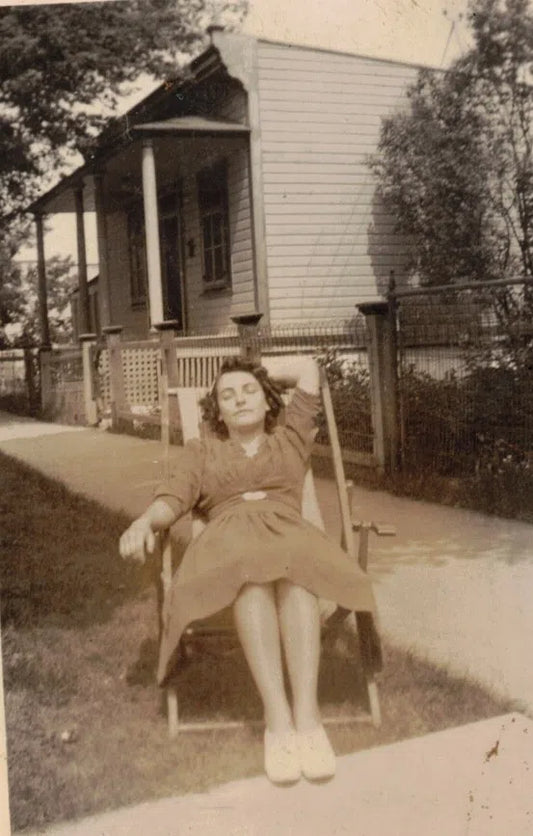 Femme sur un transat devant une maison