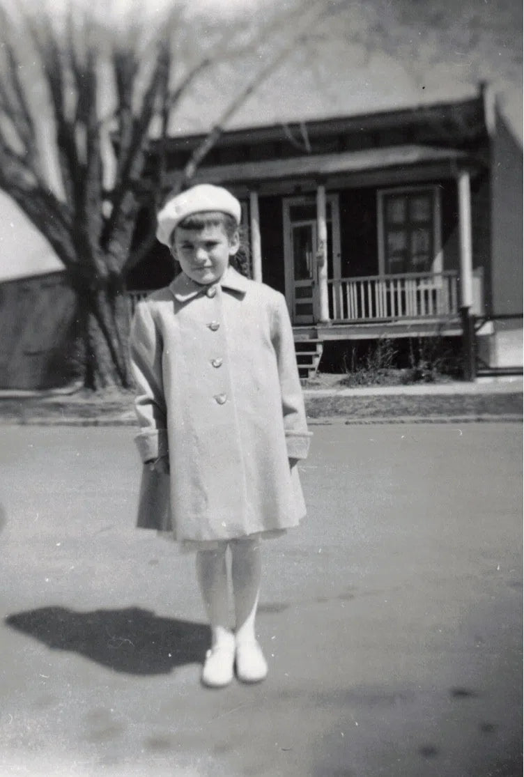 Jeune fille devant une maison