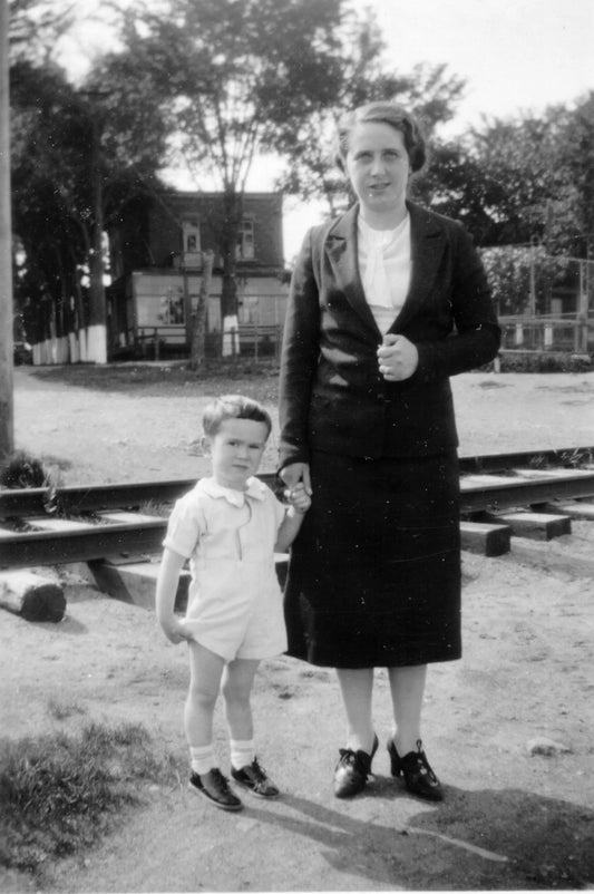 Enfant devant un chemin de fer accompagné de sa mère