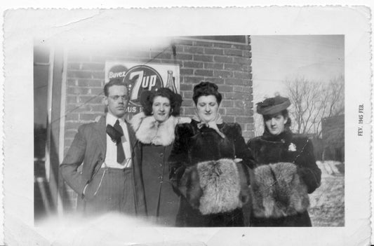 Trois femmes et un homme devant un commerce