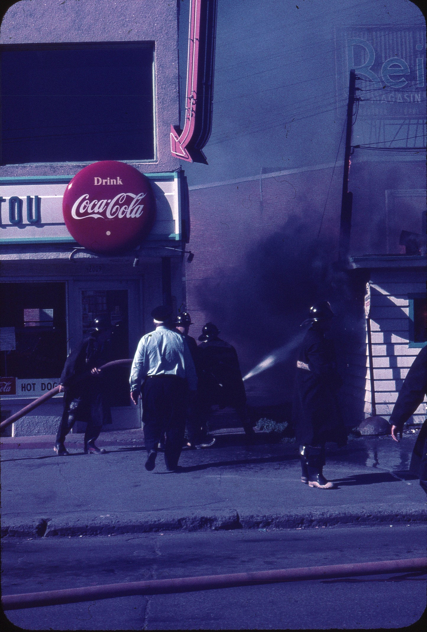 Pompiers éteignant un feu à l'intersection rue Ontario et avenue Valois, incendie juillet 1970