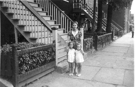 Femme et deux fillettes sur un trottoir