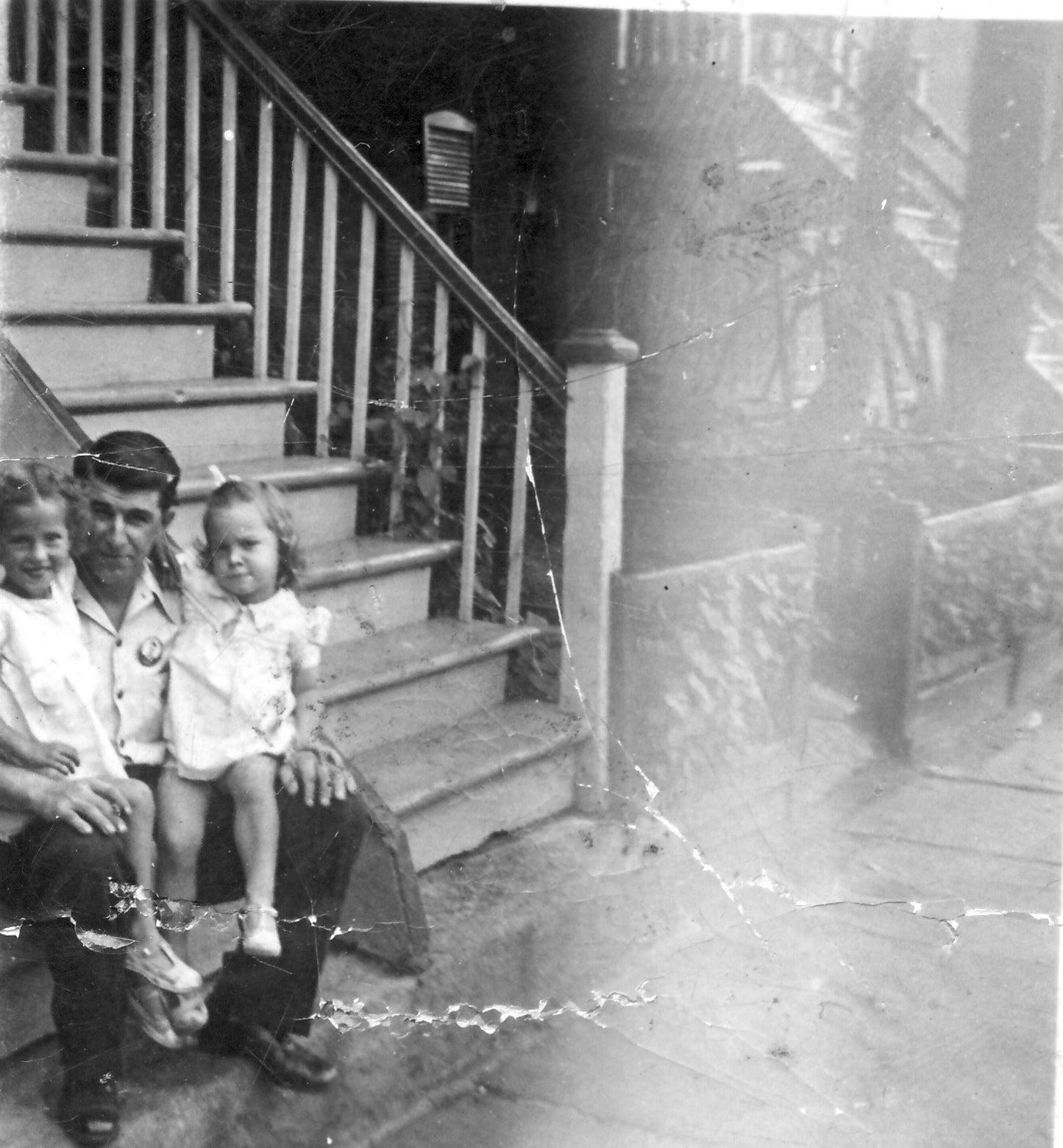 Homme et deux fillettes assis sur un escalier