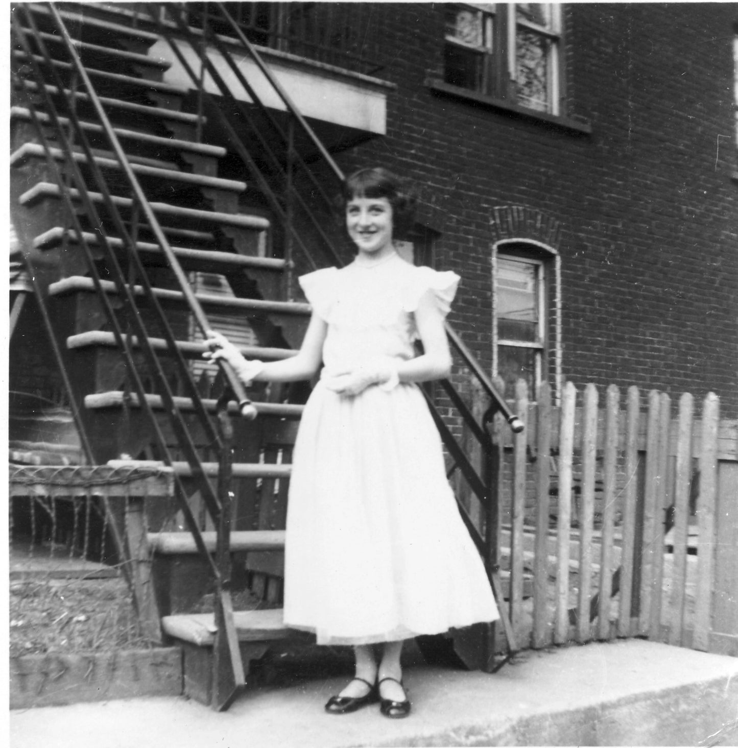 Jeune fille en robe chic devant sa maison