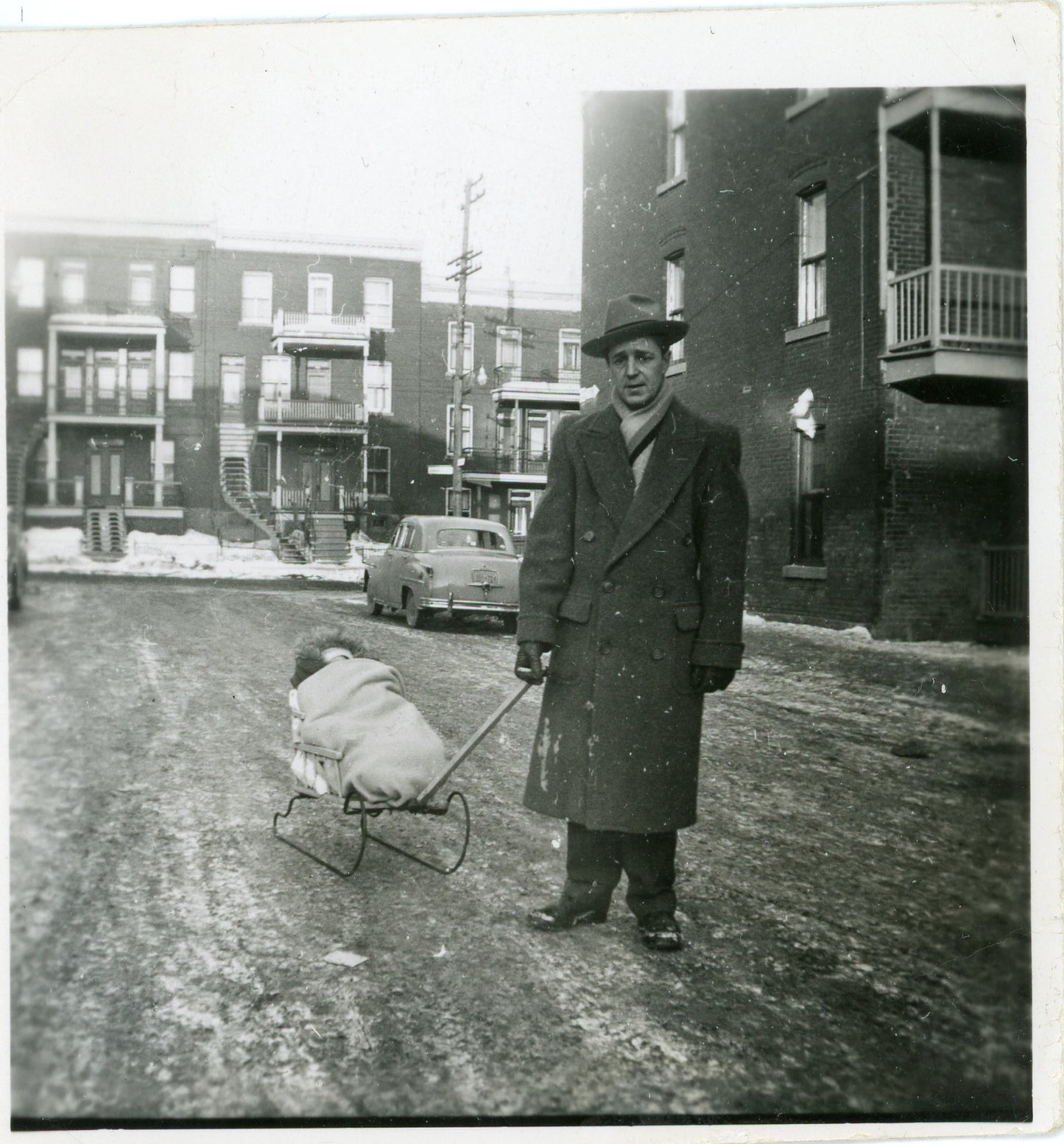 Homme avec poupon sur un traineau