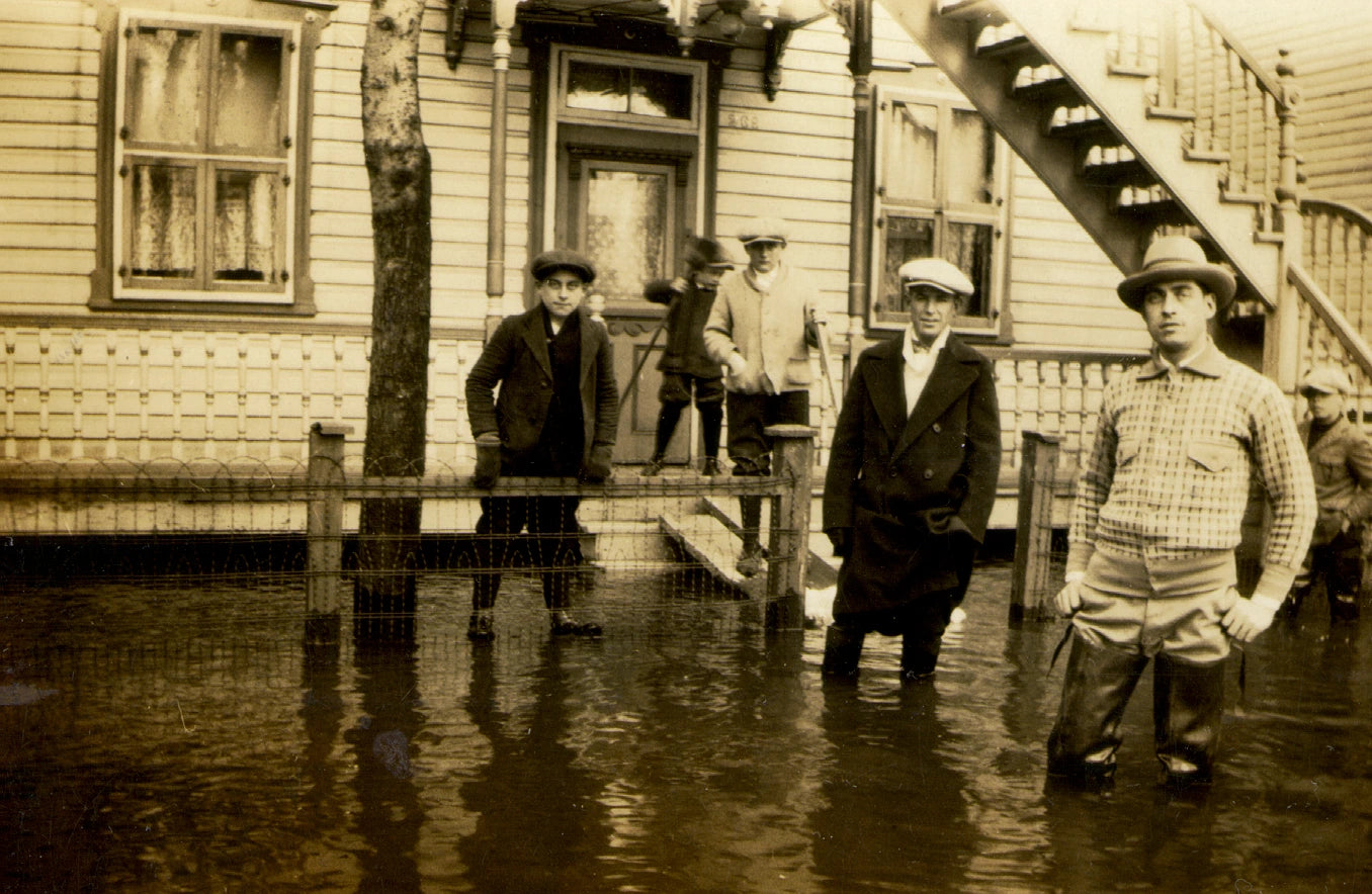 Hommes et garçons dans l'eau devant leur maison