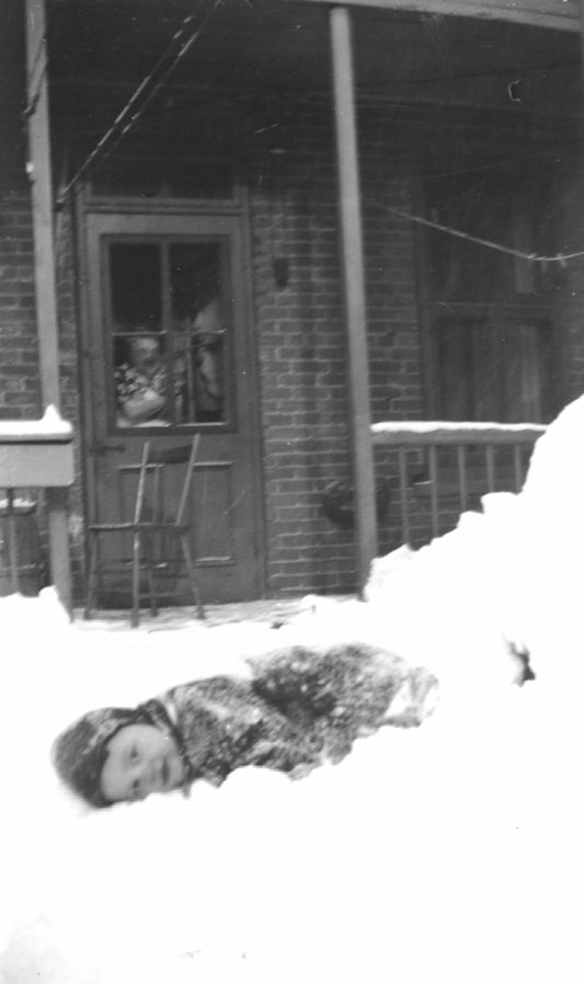 Enfant jouant dans la neige dans une cour arrière