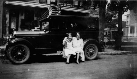 Soeurs assises sur un marchepied d'automobile