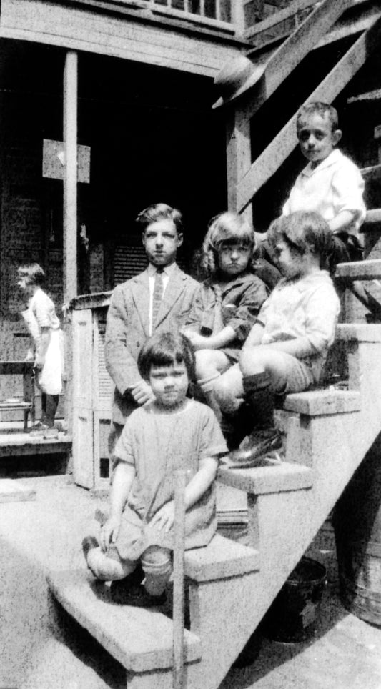 Enfants assis dans l'escalier extérieur de la cour