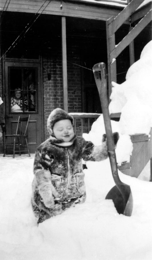 Enfant jouant dans la neige dans une cour arrière