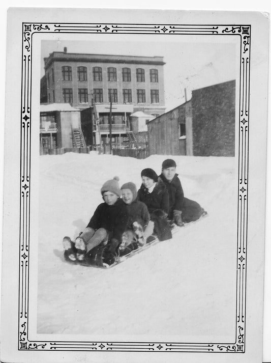 Enfants en traîneau devant l’école Saint-François-d’Assise